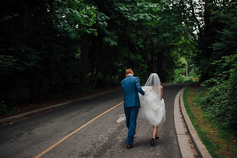 bride and groom walking down a forest road