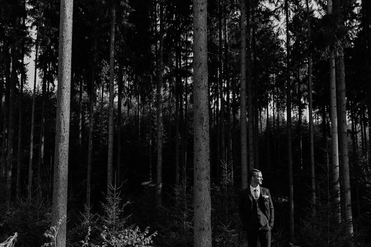 groom standing in the forest