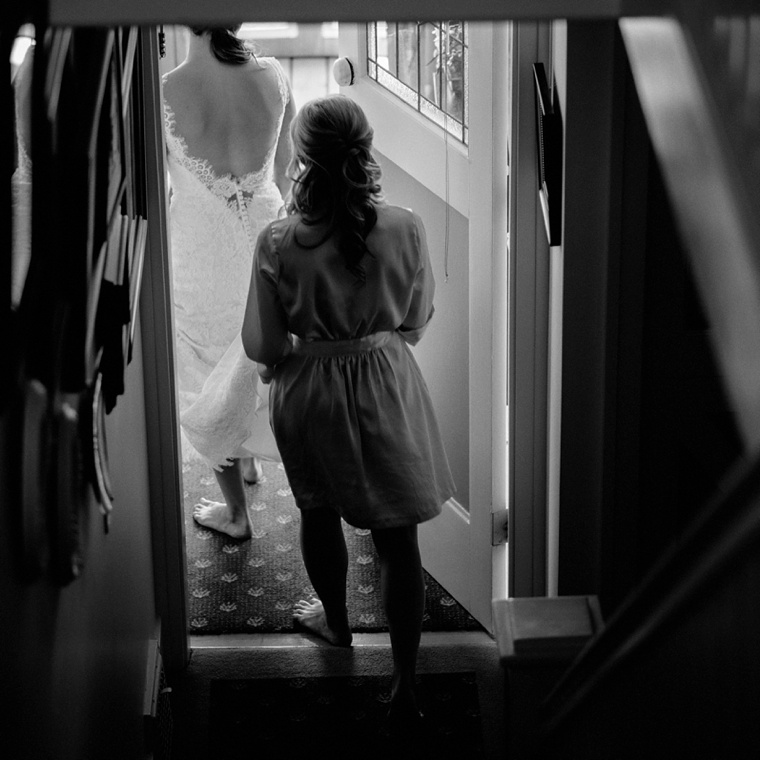 Black and white photo of bride walking out the door